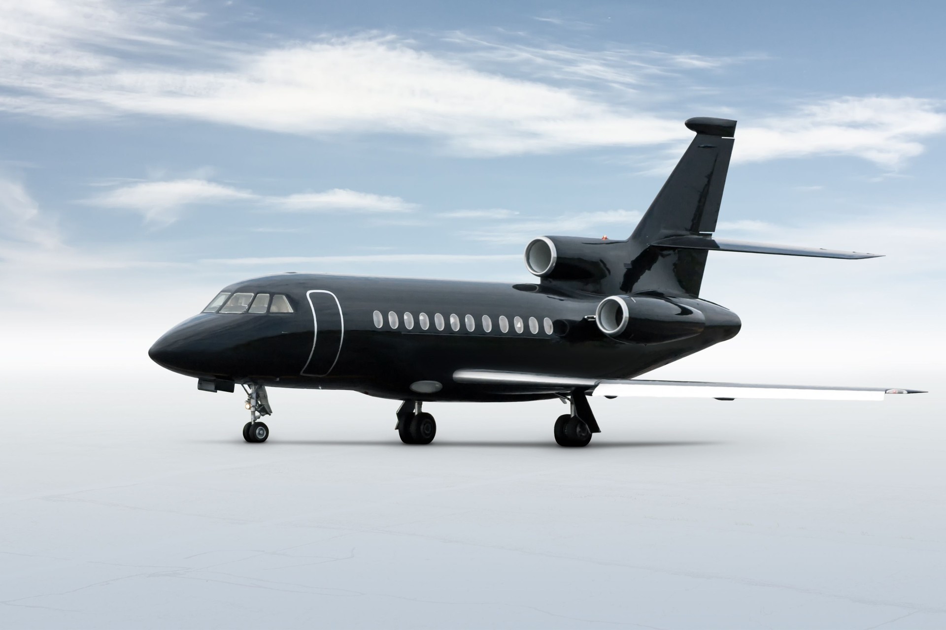 Modern black executive business jet isolated on bright background with sky Modern black executive business jet isolated on bright background with sky